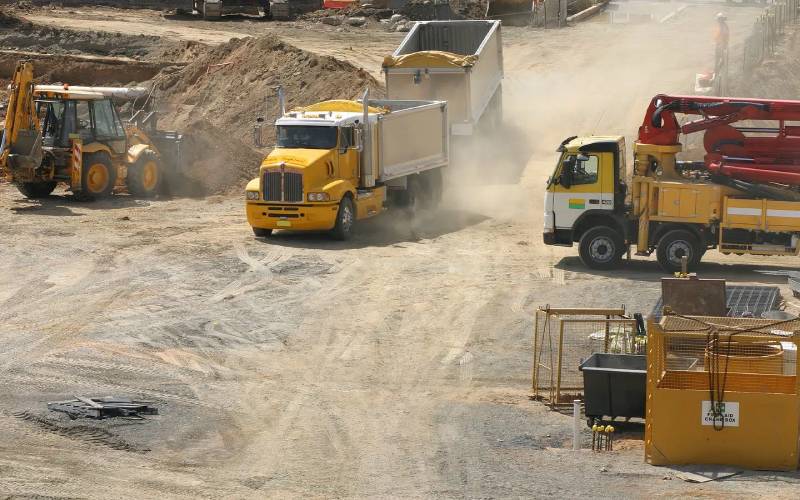 Trucks hauling dirt on a construction site.